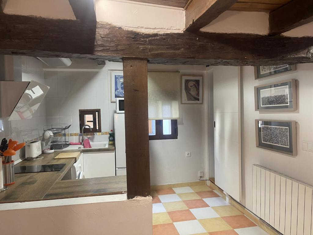 a kitchen with white walls and a wooden ceiling at ENCANTO CUENCA Mirada Al Arte in Cuenca