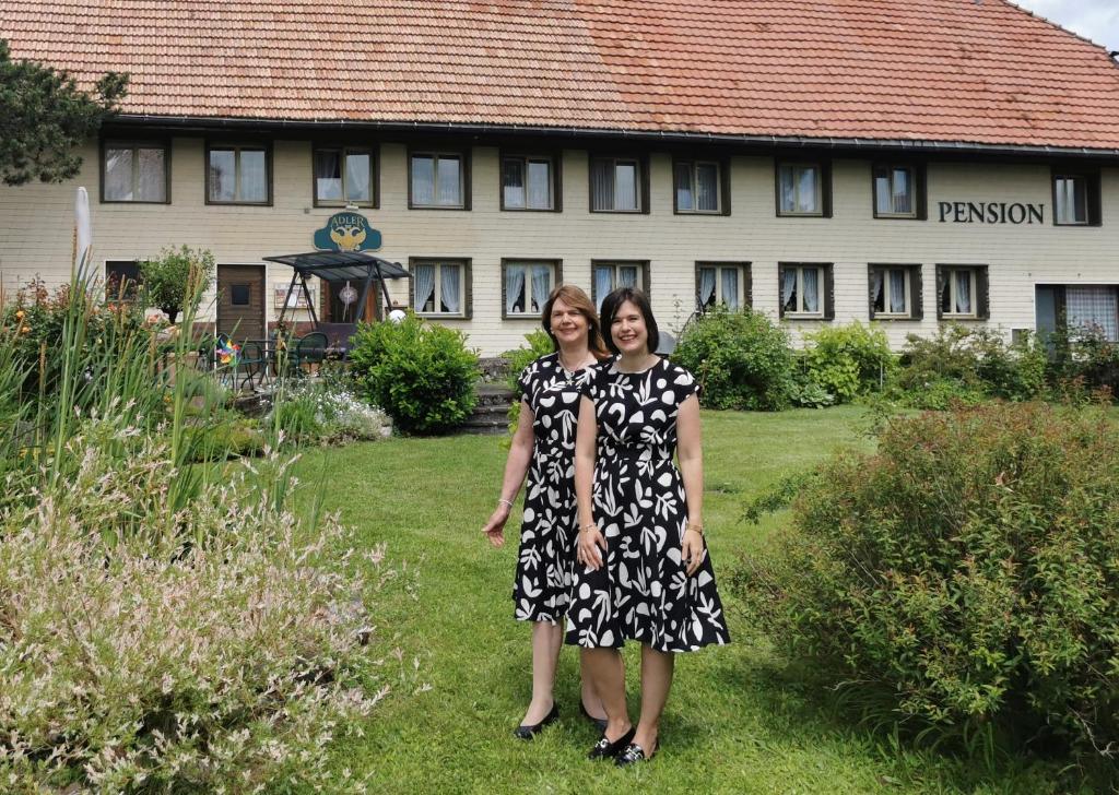 Due donne sono in piedi davanti a un palazzo di Pension Adler a Bannholz