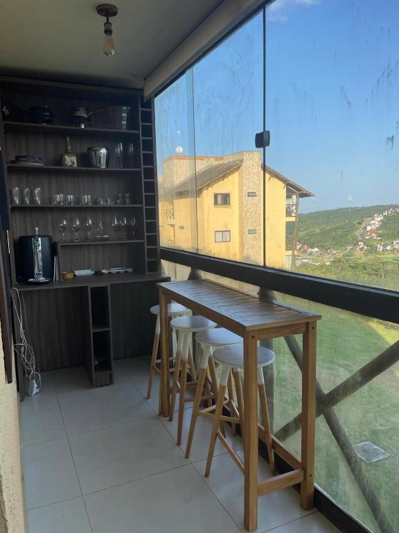 a dining room with a table and a large window at Sonhos da Serra - apartamento 201 - A in Bananeiras