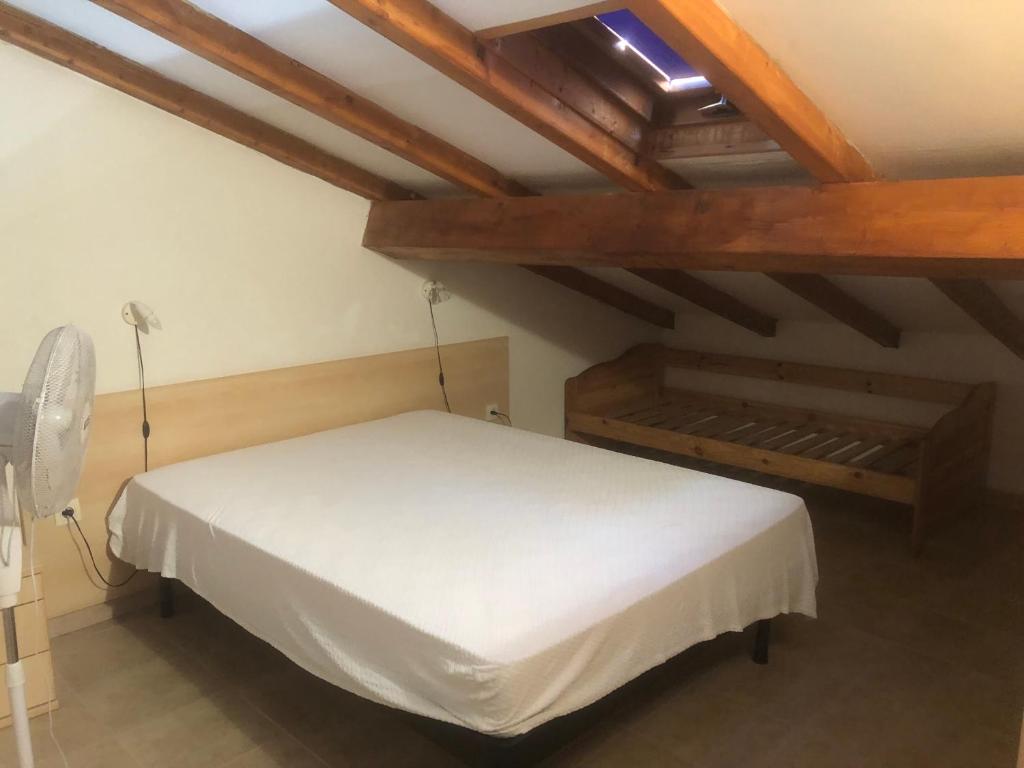 - un lit blanc dans une chambre dotée de plafonds en bois dans l'établissement Bravone, à Linguizzetta