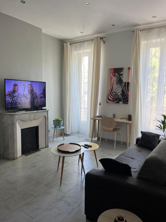 un salon avec un canapé et une cheminée dans l'établissement Plage des Catalans - Palais du Pharo - Vieux Port, à Marseille