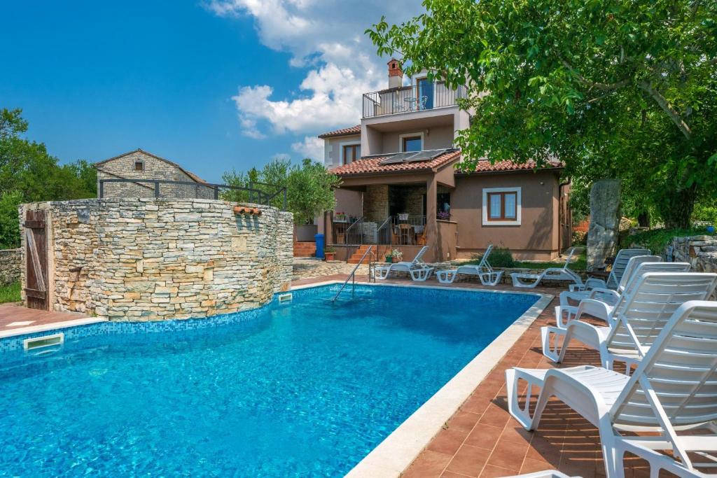 una piscina con sillas y una casa en Villa Arco, en Svetvinčenat