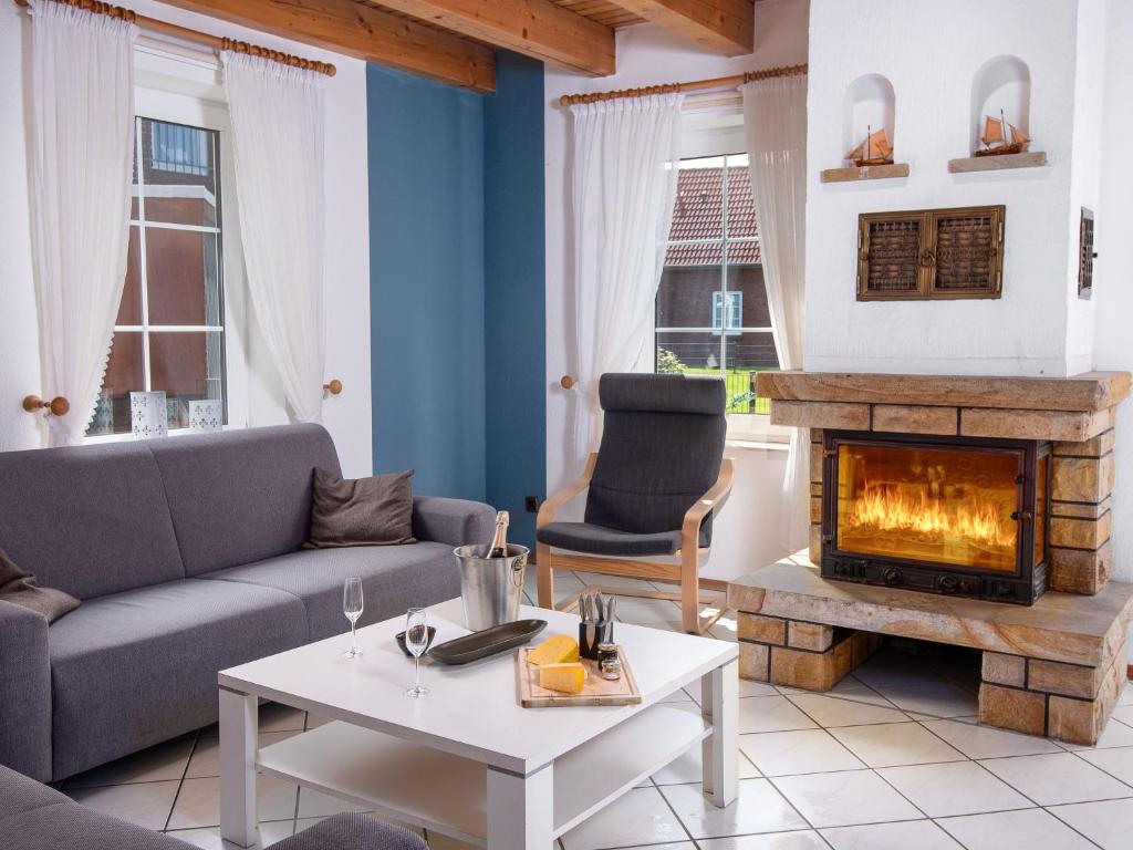 ein Wohnzimmer mit Couch und Kamin in der Unterkunft Holiday Home Riedehuus by Interhome in Norddeich