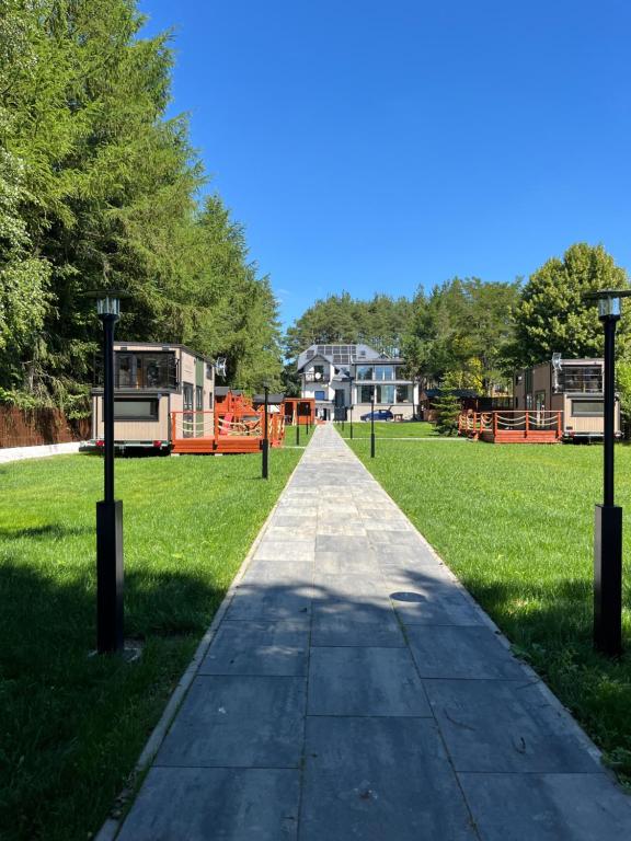 a walkway in a park with houses in the background at Apartamenty Zielona Dolina nr 2 in Szteklin