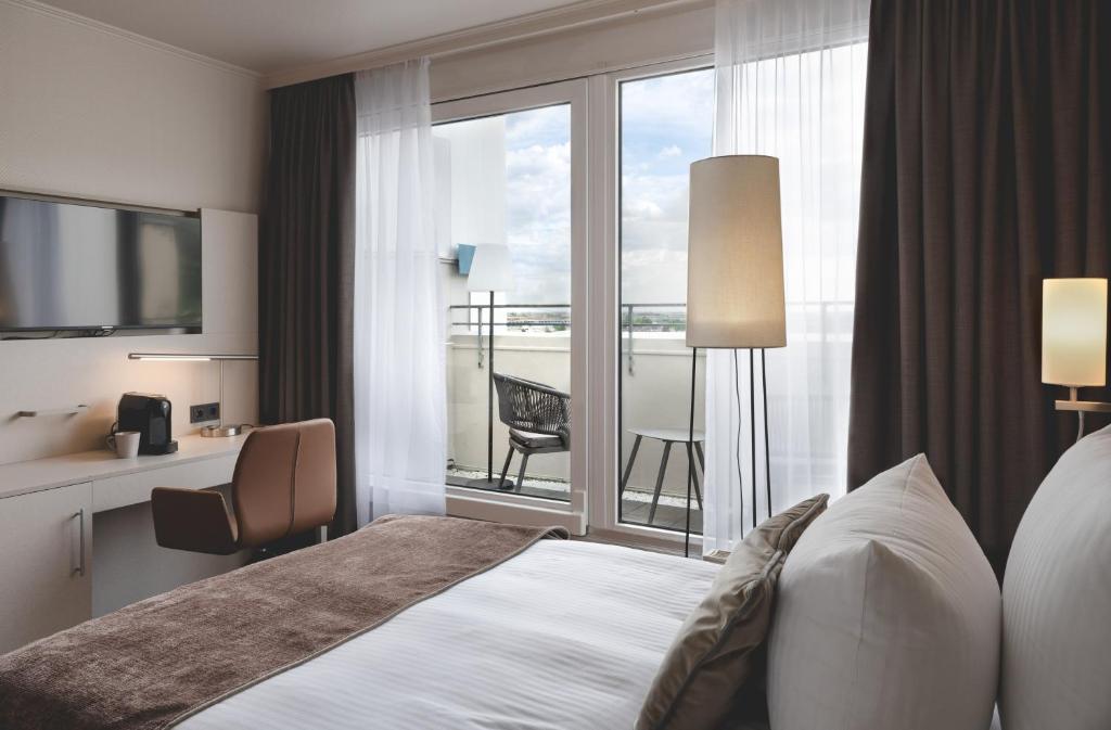 Postel nebo postele na pokoji v ubytování Leonardo Hotel Heidelberg City Center