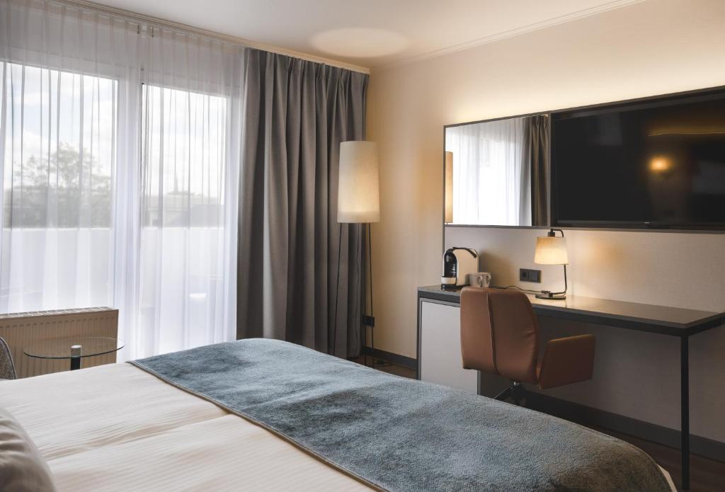 Postel nebo postele na pokoji v ubytování Leonardo Hotel Heidelberg City Center