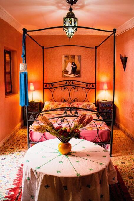 a bedroom with a bed and a table with a vase on it at Riad - In Medina - Kesh Design in Marrakesh