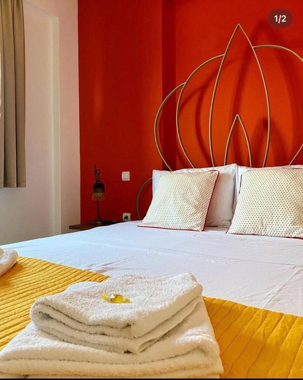 a bedroom with a bed with a red wall at Dominique Rooms Meteora in Kalabaka