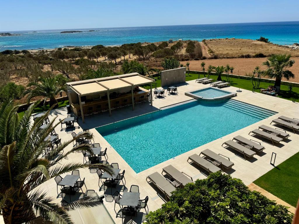 an overhead view of a swimming pool with chairs and the ocean at Pachia Ammos Falasarna in Falasarna