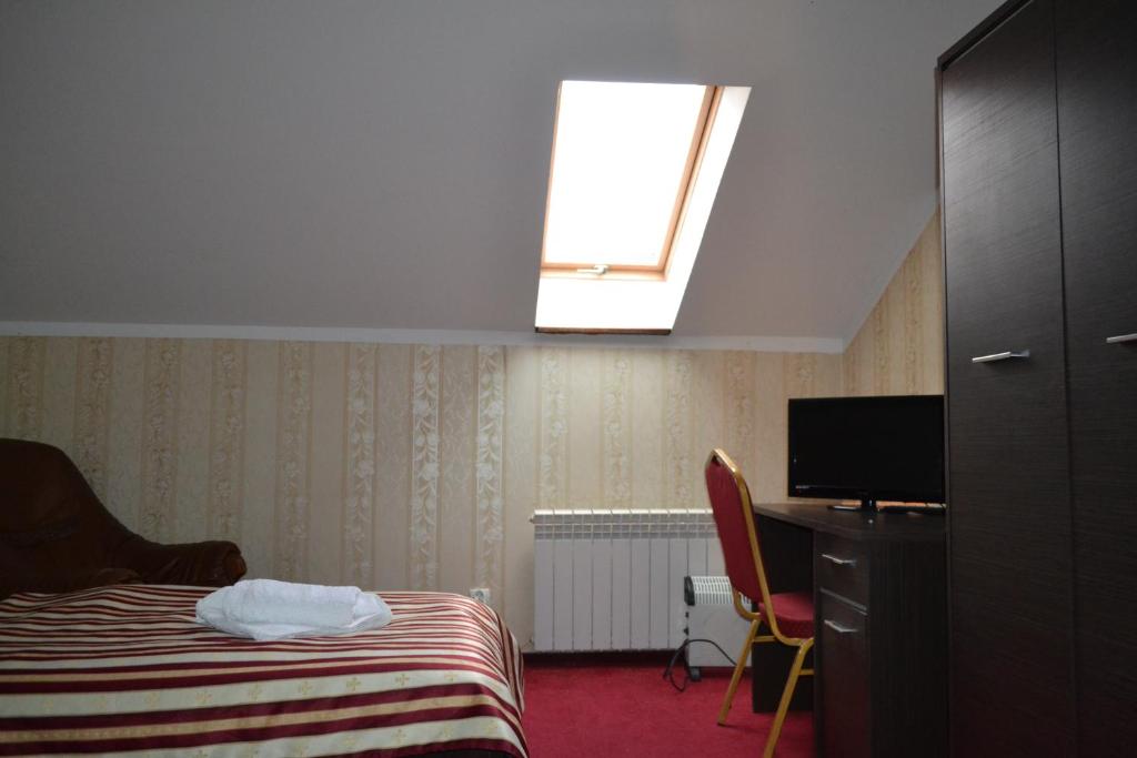 Habitación de hotel con cama y tragaluz en Noclegi Capitto en Kostrzyn nad Odrą