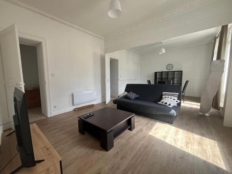 un salon avec un canapé et une table basse dans l'établissement L'Entracte Cherbourgeois, à Cherbourg en Cotentin