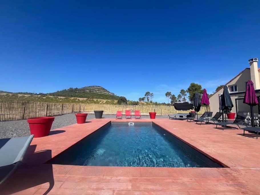 - une piscine avec des chaises longues et une piscine dans l'établissement Maison de charme, piscine et vue panoramique, à Mudaison