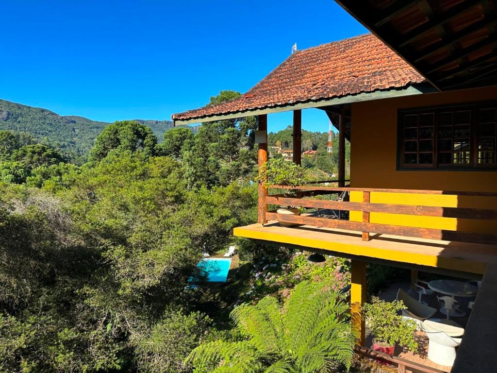 a building with a bench on the side of it at Pousada da Trilha in Monte Verde