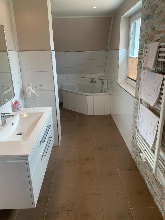 a bathroom with a sink and a bath tub at Casa Belvedere in Göhren-Lebbin