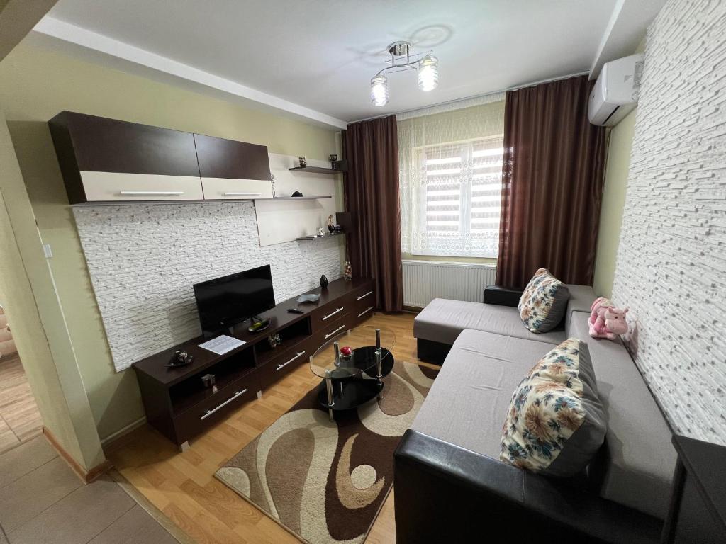 Una sala de estar con un sofá y un televisor. en Azal, en Turda