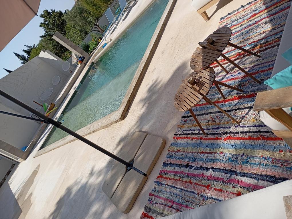 a rug on the side of a building next to a pool at Studio avec piscine in Nîmes