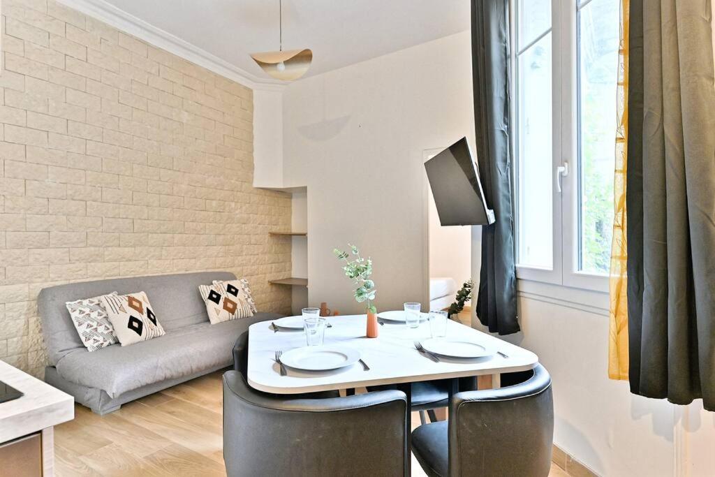 un salon avec une table et un canapé dans l'établissement Appartement 2 chambres Pyrénées Alexandre Dumas-II, à Paris