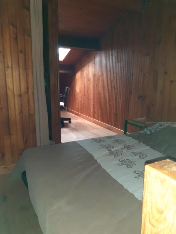 une chambre avec un lit et une chaise dedans dans l'établissement segura, à LʼIsle-Jourdain