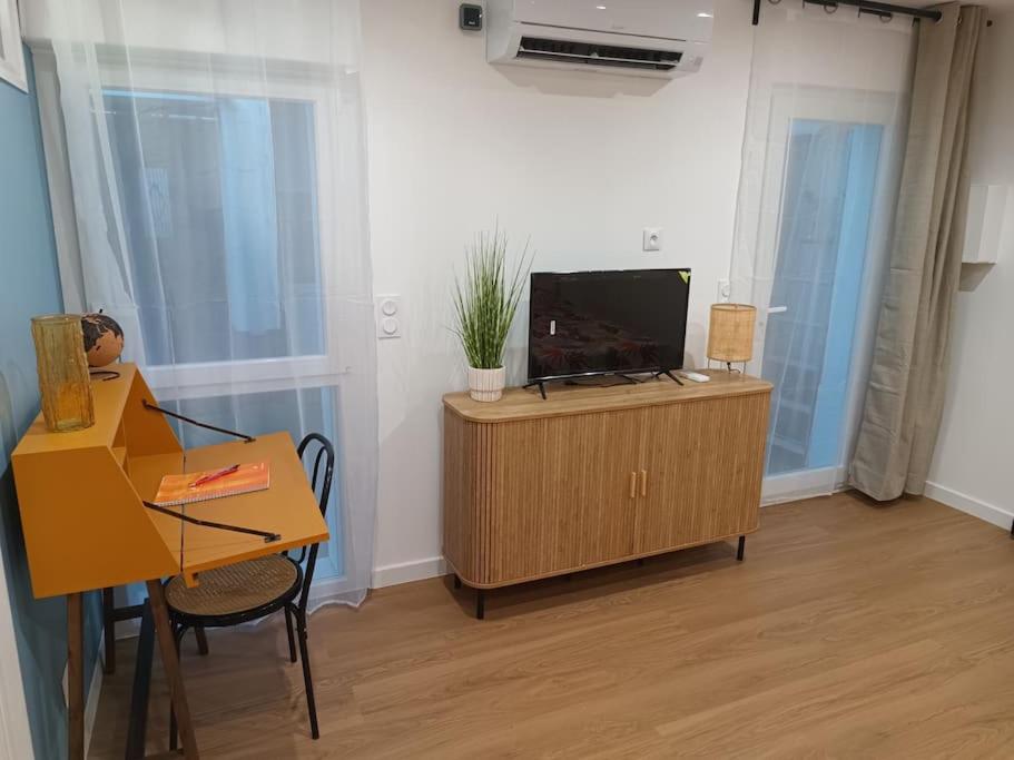 - un salon avec une télévision sur un meuble en bois dans l'établissement Charmant studio centre-ville Montpellier, à Montpellier