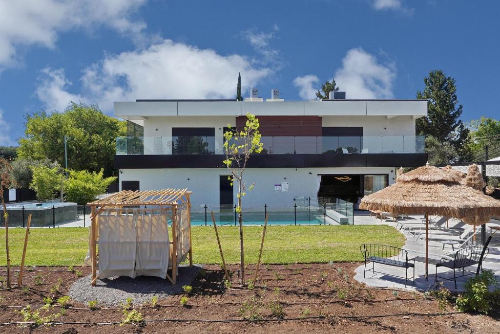 une maison avec un bâtiment en arrière-plan avec une cour dans l'établissement אסיה ריזורט-Asia resort, à Mishmār Hāyardin