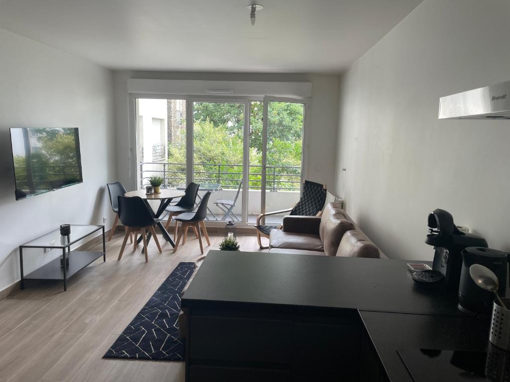 un salon avec un canapé et une table dans l'établissement Charmant deux pièces avec balcon, à Saint-Denis