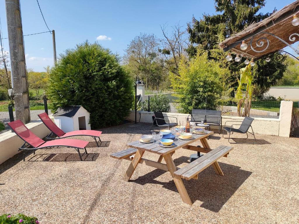un patio con tavolo e sedie in legno di L'Autre Maison a Lucet