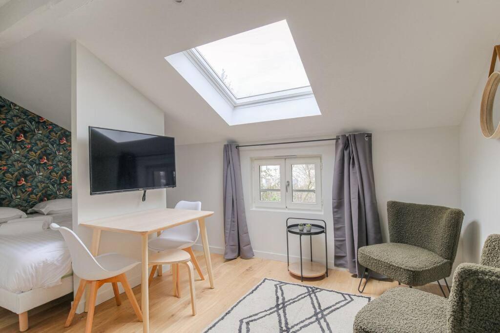 - un salon avec une table et une lucarne dans l'établissement Appartement neuf, clim et parking, Caluire-Cité Intl, à Caluire-et-Cuire