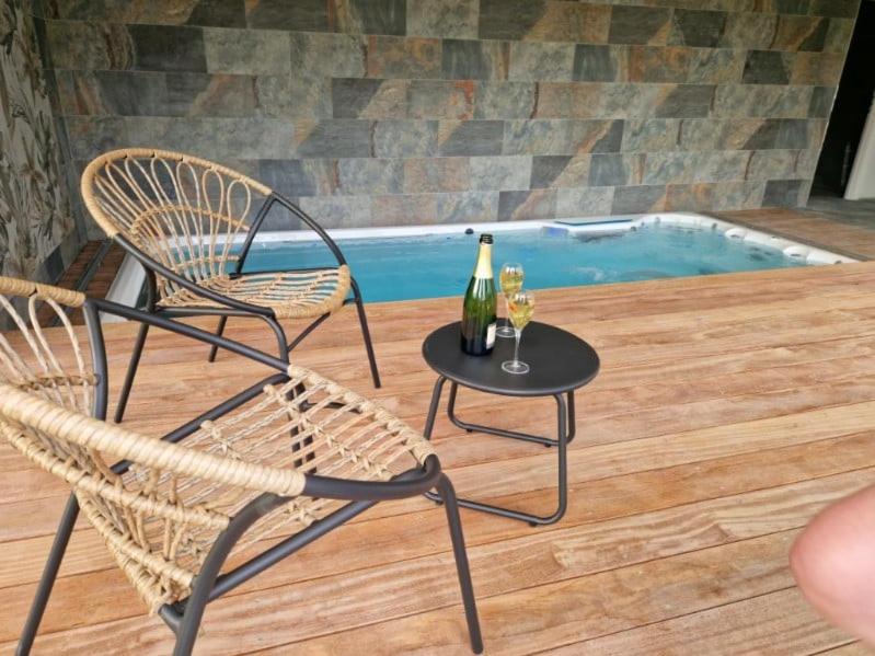 - deux chaises et une table avec une bouteille de vin dans l'établissement Escapade Romantique à Saint Omer-Espace Totalement Privatisé Avec Terrasse, à Saint-Omer