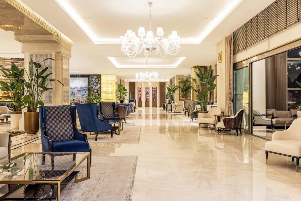 a lobby of a hotel with chairs and tables at CVK Park Bosphorus Hotel Istanbul in Istanbul