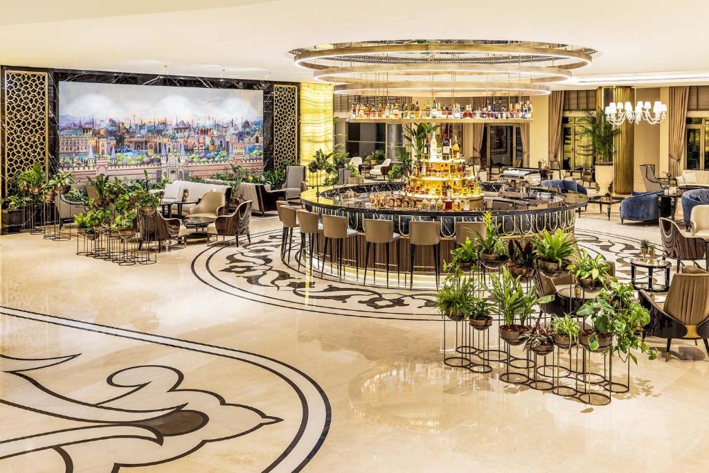 a hotel lobby with a bar and tables and chairs at CVK Park Bosphorus Hotel Istanbul in Istanbul