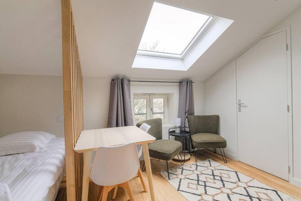 a bedroom with a bed and a table and chairs at Studio cosy, climatisé, Caluire-Lyon in Caluire-et-Cuire
