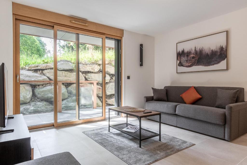 un salon avec un canapé et une table dans l'établissement Alpage Mont Blanc, à Combloux