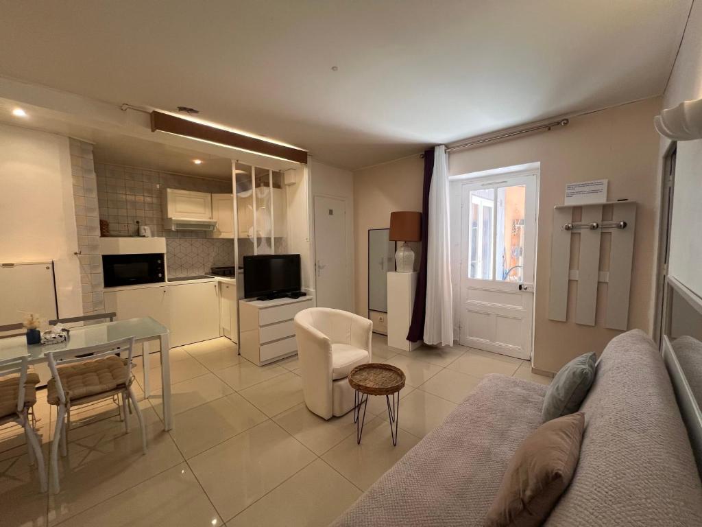 un salon avec un canapé et une table et une cuisine dans l'établissement B031 2 chambres 6 personnes terrasse au centre historique, à Cannes