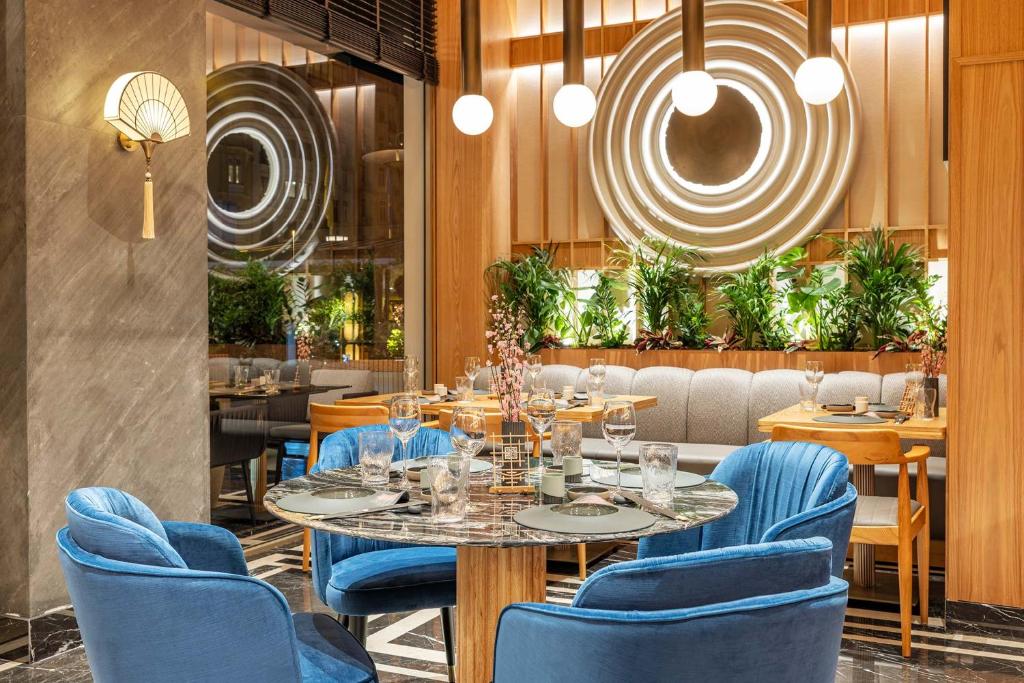 a dining room with a table and blue chairs at CVK Park Bosphorus Hotel Istanbul in Istanbul