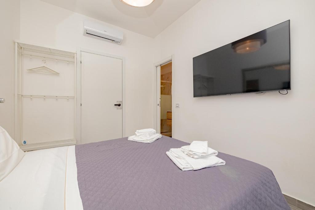 une chambre avec un lit avec une télévision au mur dans l'établissement Cozy Room - 2, à Milan