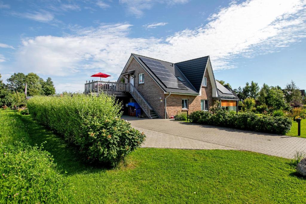 una casa di mattoni con un tetto nero e un balcone di Ferienwohnung Windrose a Waldhusen