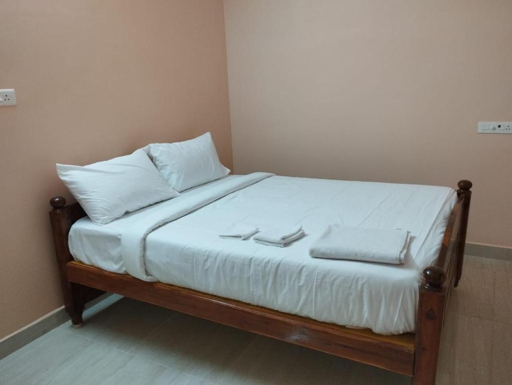 Una cama con sábanas blancas y almohadas blancas. en Villa Eden 1bhk, en Pondicherry