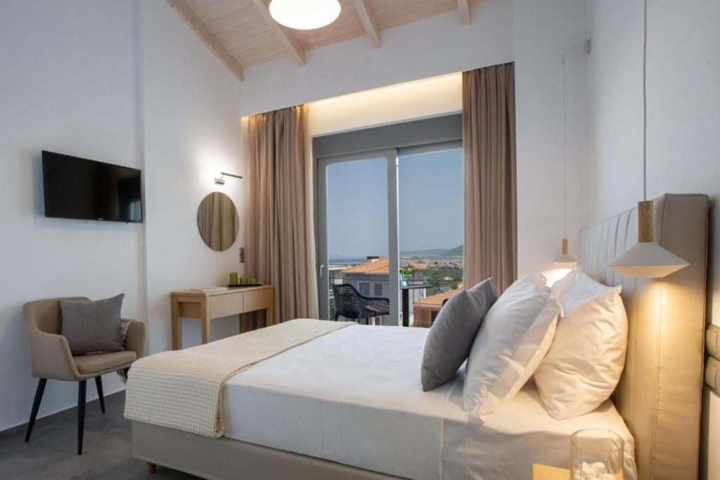 a bedroom with a bed and a large window at Aloft Luxury Villas Lefkada - Heated pool Lefkia Villa in Apolpaina