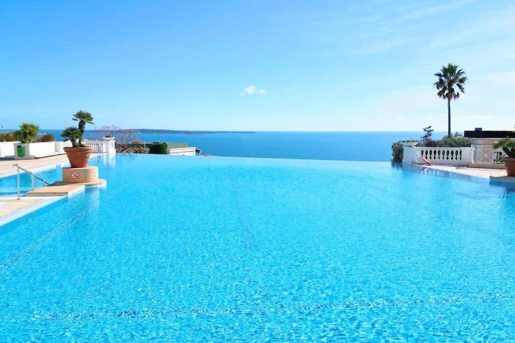 une grande piscine bleue avec vue sur l'océan dans l'établissement 4 people with Pool Tennis Parking air cond, à Cannes