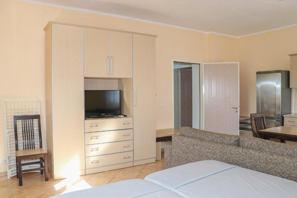 a bedroom with a couch and a tv in a room at Villa Apet 23 in Shkodër