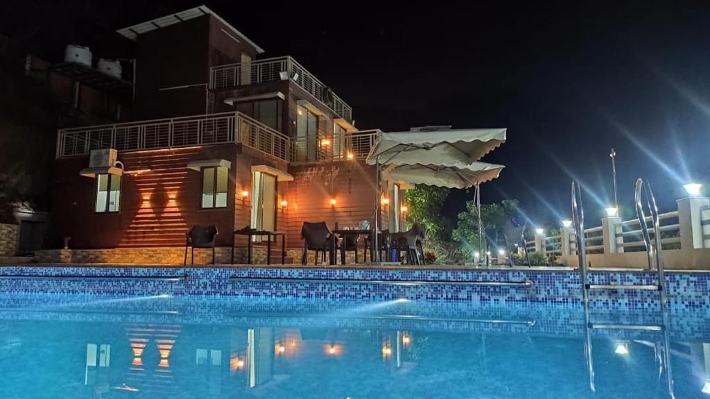 a house with a swimming pool at night at Skyview Villa Udaipur with private pool 4Bhk Villa in Udaipur