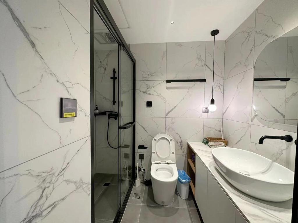 a bathroom with a sink and a toilet and a shower at 同济佳苑公寓 in Shanghai