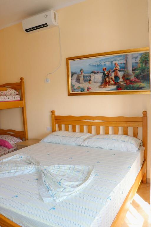 a bed in a bedroom with a picture on the wall at Villa Apet 23 in Shkodër