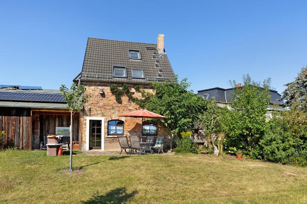 une maison avec une table et des chaises dans une cour dans l'établissement Cottage Im Fläming - Ferienwohnung, à Wiesenburg