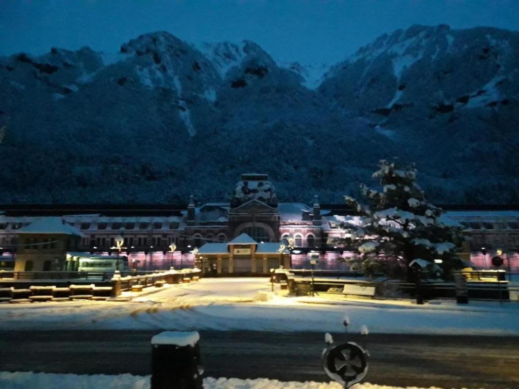 una ciudad con un edificio y una montaña cubierta de nieve en The family bienvenidos a Canfranc, en Canfranc-Estación