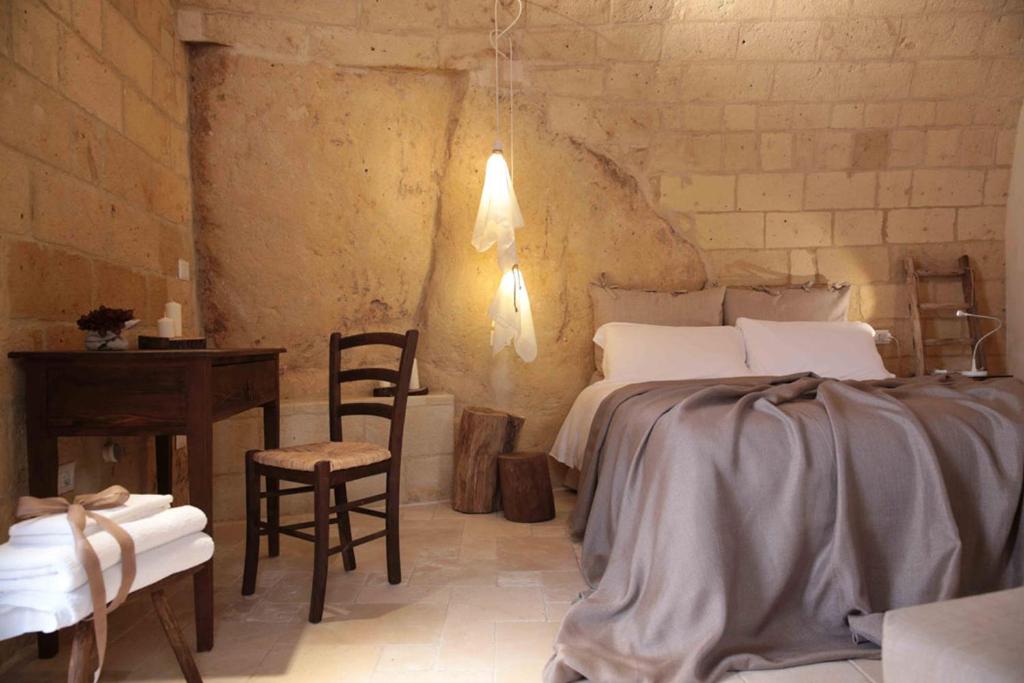 1 dormitorio con 1 cama, mesa y sillas en Fondo Vito, en Gravina in Puglia