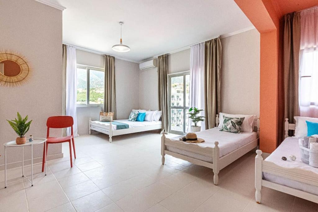 a living room with two beds and a chair at Himara City 33 - Central, Beach Access in Himare