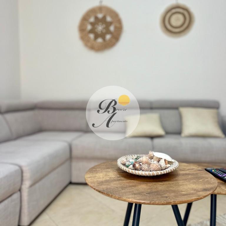 a living room with a couch and a table with a bowl of food at Breeze Home in Vlorë