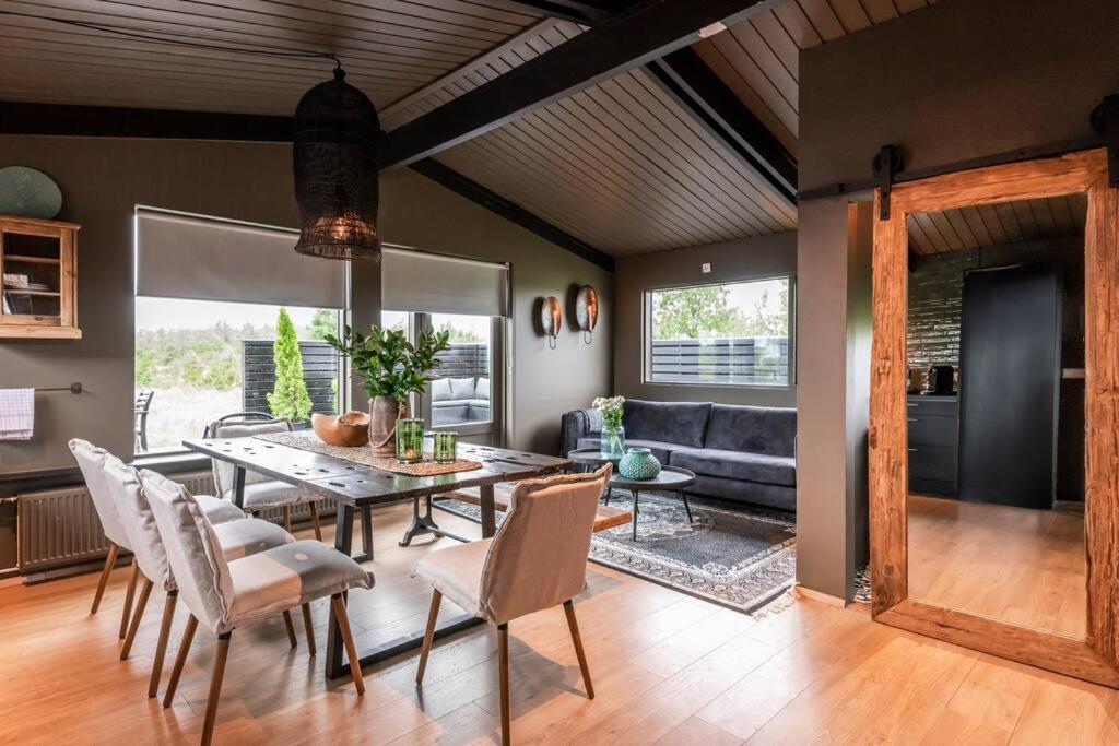 MiðdalurModern Summerhouse Views Outdoor Spaces Patio的带餐桌和椅子的客厅