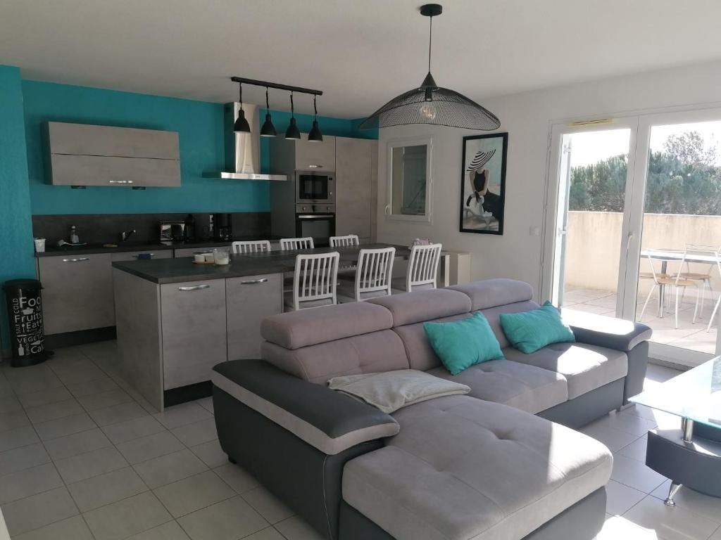 un salon avec un canapé et une cuisine dans l'établissement La Cigale, à Bagnols-en-Forêt